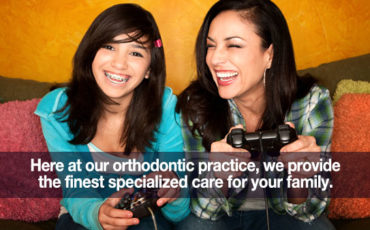 Two women playing video games on a couch with the text, at our orthodontic practices we provide the most specialized care for your family.
