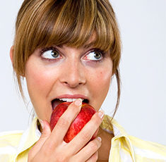 A woman eating an apple.