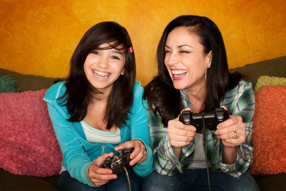 Two women playing video games on a couch.