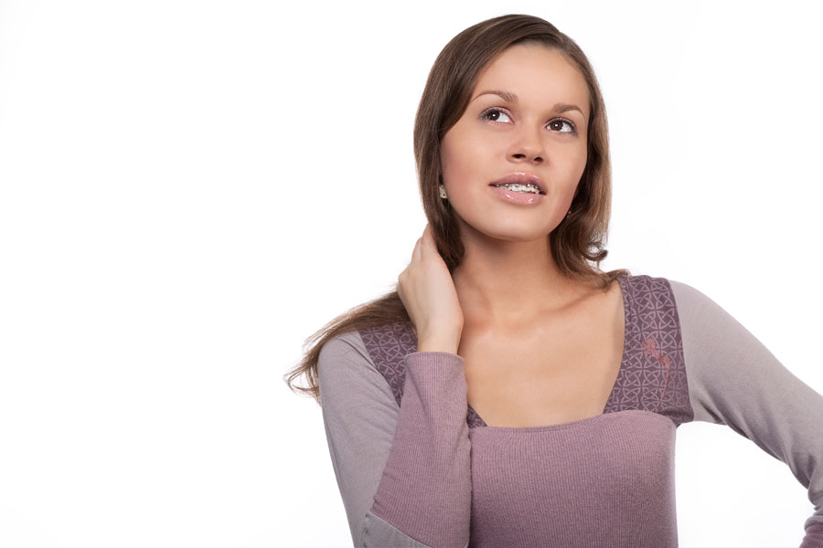 A young woman posing with her hand on her shoulder.