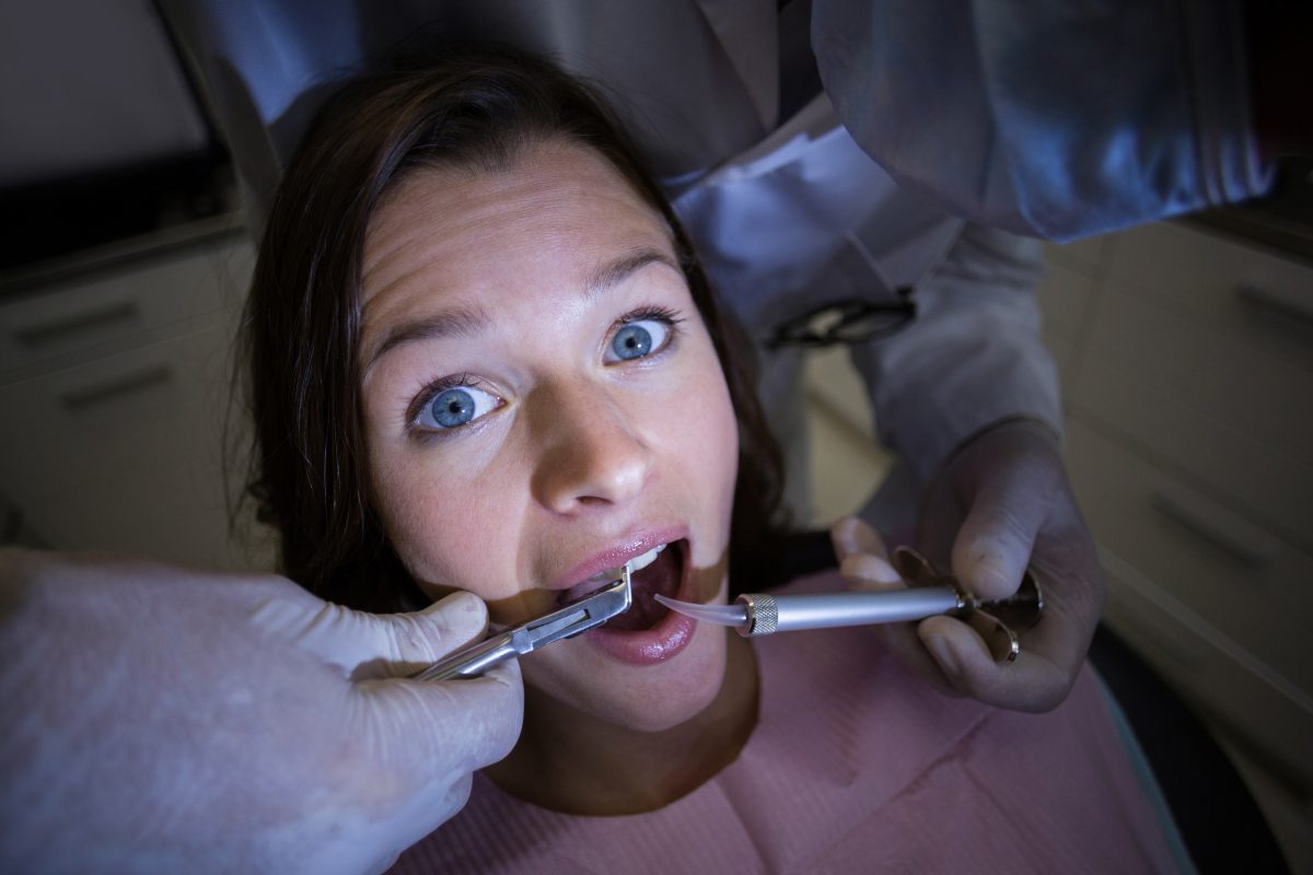 A woman is being examined by a dentist.