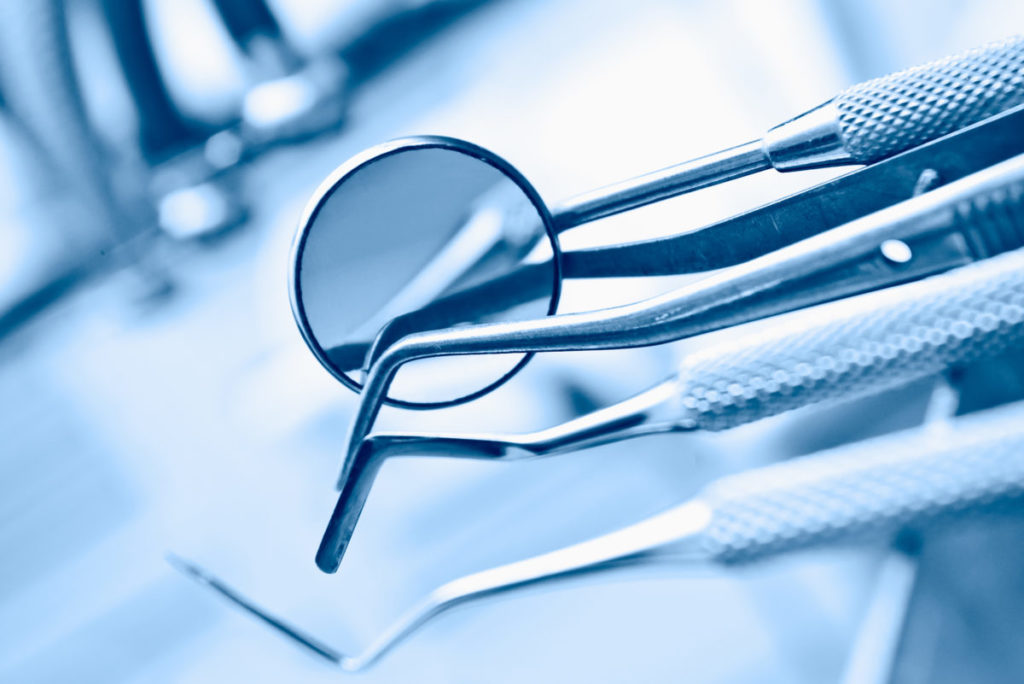 A group of dental utensils with a magnifying glass.