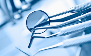 A group of dental utensils with a magnifying glass.