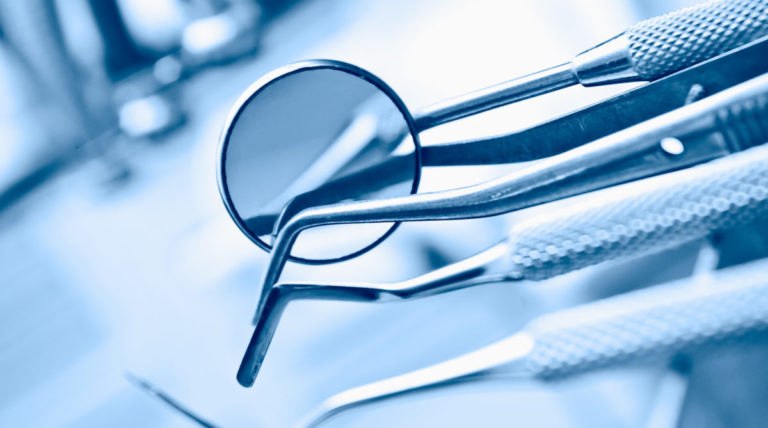 A group of dental utensils with a magnifying glass.