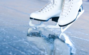 A pair of white ice skates on the ice.