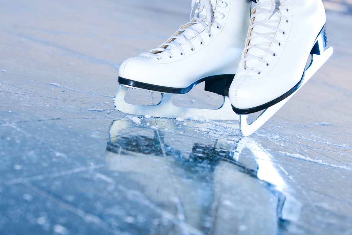 A pair of white ice skates on the ice.