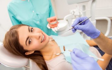 A woman is getting her teeth cleaned in a dentist's office.