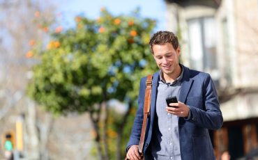 A man in a suit is looking at his cell phone.