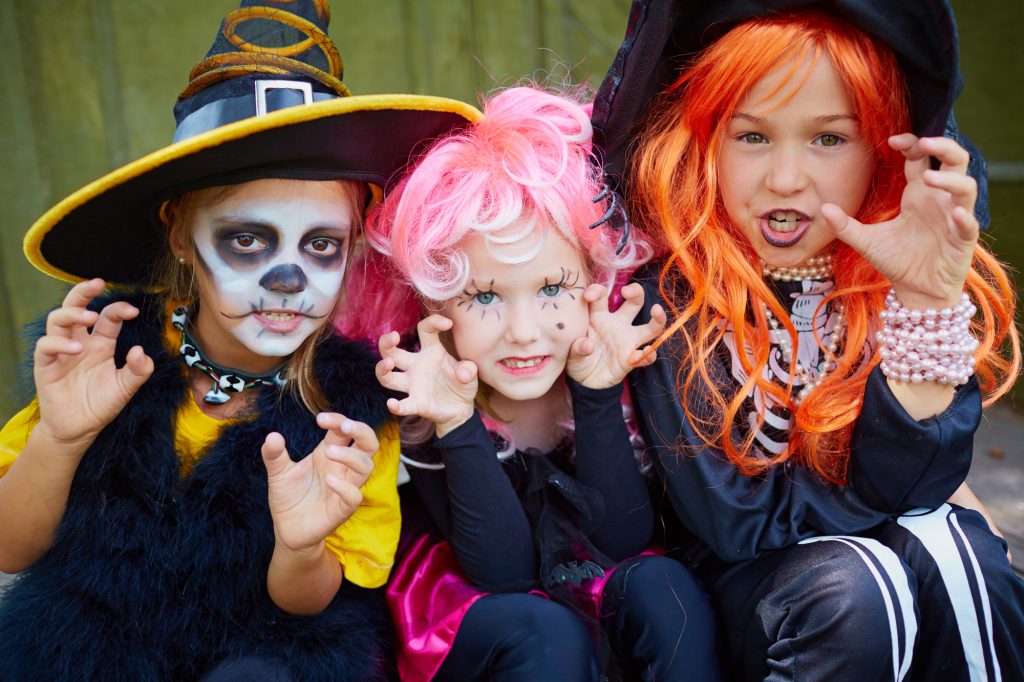 Three children dressed up as witches and witches.